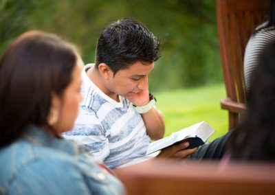 A mother and son reading scripture outside